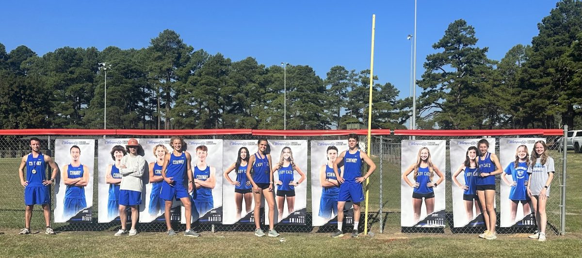 Wampus Cat Seniors pose in front of their senior banners after their races at the Wampus Cat Invitational at Lake Beaverfork on September 30.