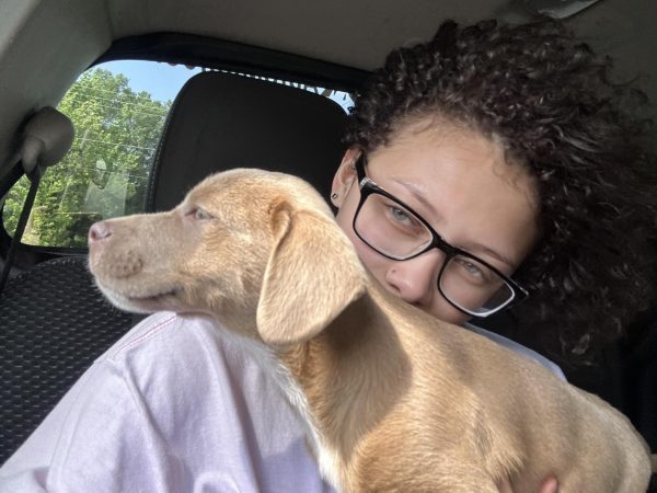 Junior Aleca Wells and her dog rocky posing for a picture