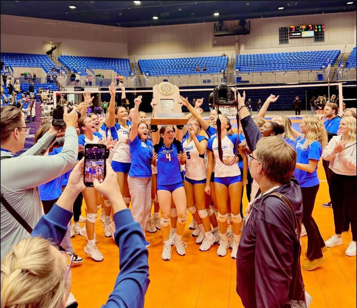 Bishop Flyod and Conway Varsity Volleyball girls celebrate with their State Championship trophy.
