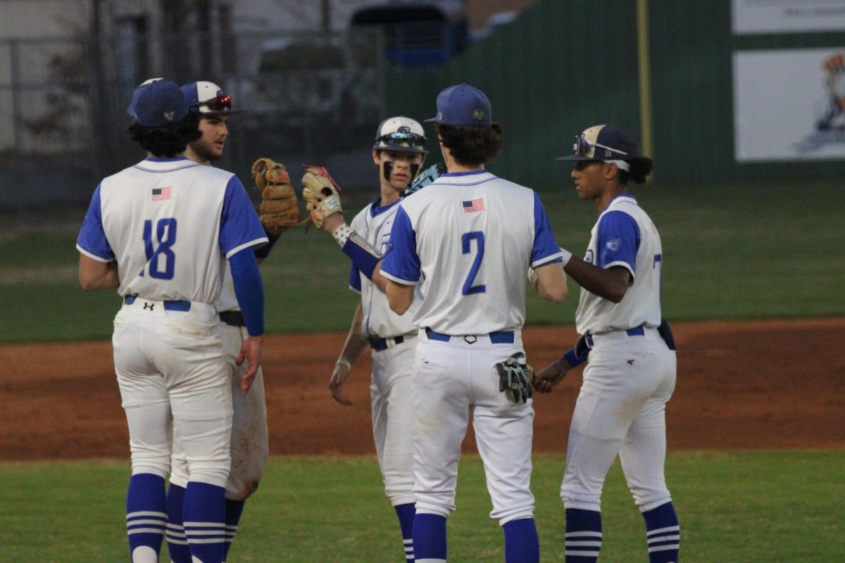 Players discuss the next play on the pitcher's mound. 