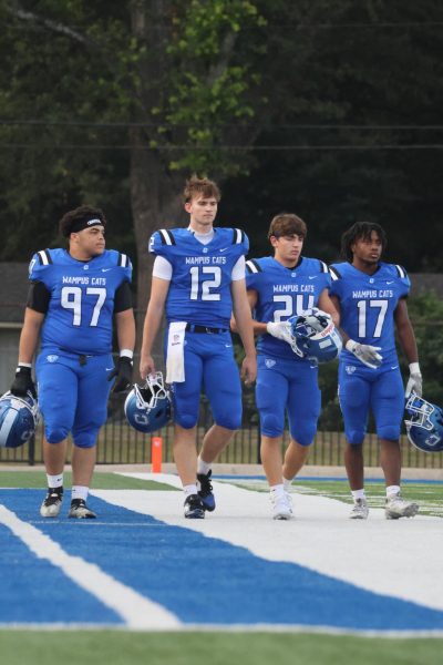 Trayvon Logan, pictured right, walk with fellow seniors on the field before the game. 