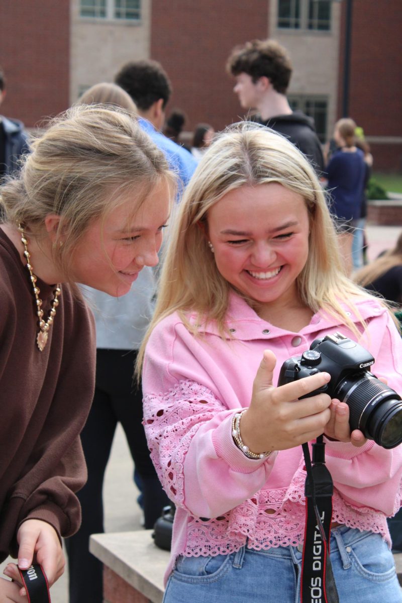 Sophomores Avery Gray Corinne Hankins laugh over a picture taken at a photography workshop.