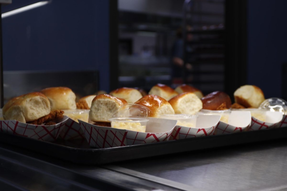 Chicken with rolls waiting to be picked up in the cafeteria.
